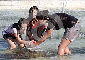 Kids play in a water of a fountain on a sunny summer day during summer break in Sofia, Bulgaria Ã¢â¬â june 15, 2012. Sunny weather c